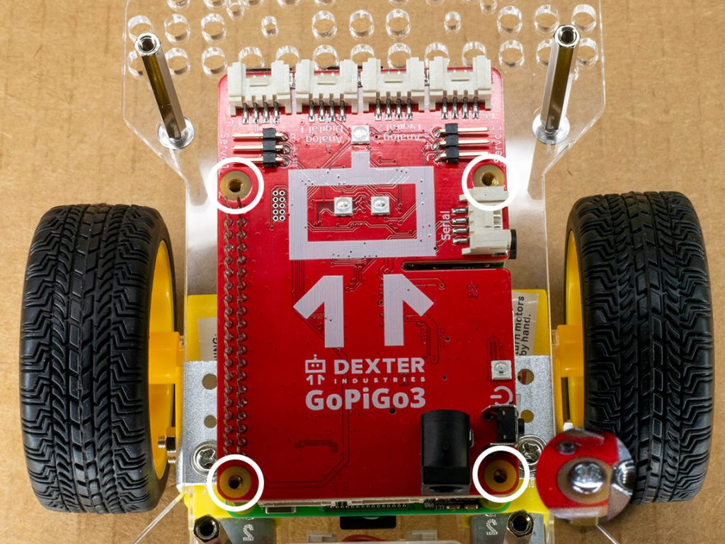 Use a small screw to secure the red GoPiGo electronic board using the four holes in the corners.